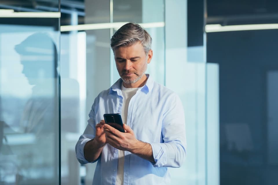 A man checking his phone in a modern office